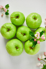 Flat lay Apple flowers and ripe green apples on a white background, Fruits and flowers, sping concept. Top view