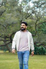 Young and confident indian man giving expression at park.