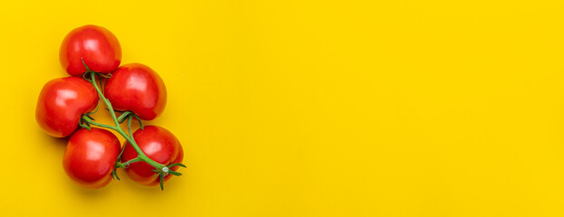 Tomato on a branch sprout top view flatlay on a yellow background. Fresh juicy ripe tomato Red Cherry fruits. Salad preparation ingredients. Empty copy space for mockup