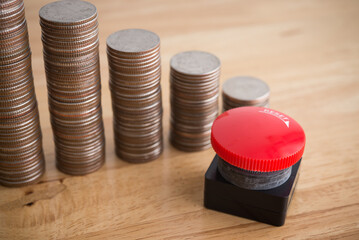 Stack coins as chart falling down and red stop reset button on wooden table background copy space. Stop reset recession economy, global world economic crisis, inflation or FED control interest rates.