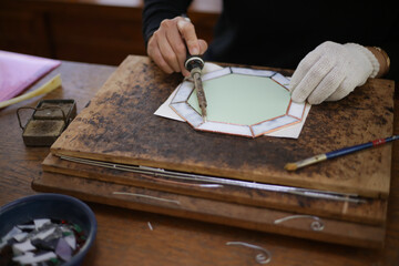 ステンドグラスミラーの製作をする女性