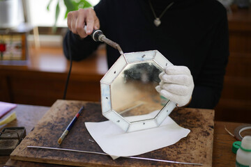 ステンドグラスミラーの製作をする女性