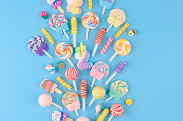 Explosion of decorative candies, lollipops and ice cream. Top view on blue background - 563279629