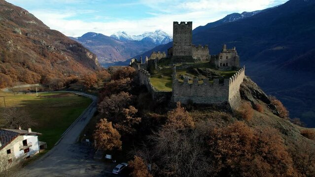 Italy, Medieval impressive castle Cly surrouded by Alps mountains in Valle d'aosta (Aosta valley), aerial drone 4k hd video