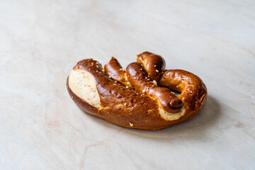 Bitten Leftover Pretzel on Marble Surface.