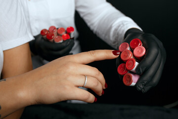 Cosmetician helps the client to choose lip pigment for permanent makeup