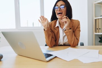 Business woman working in the office at her desk with a laptop, smile and business dialogue via...