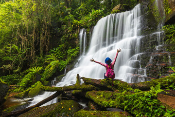 Young woman hiking on beautiful waterfall in Phu Hin Rong Kla National Park, Phitsanulok  province,...