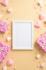 Valentine's Day concept. Top view vertical photo of photo frame present boxes heart shaped marshmallow candles and sprinkles on isolated beige background with copyspace