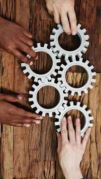 Hands Holding Interlocked Gear Wheels