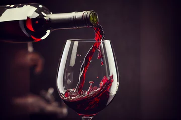 Fotobehang Rotwein fließt aus einer Flasche in ein Weinglas mit Platzhalter im Hintergrund - Generative Ai © Sarah