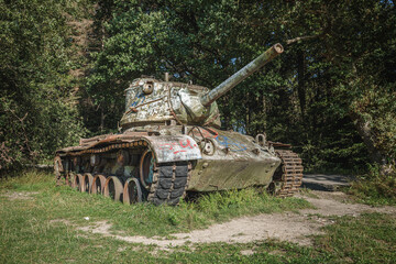 alter kaputter Panzer mit Graffiti besprüht mitten in einer Lichtung in einem Wald