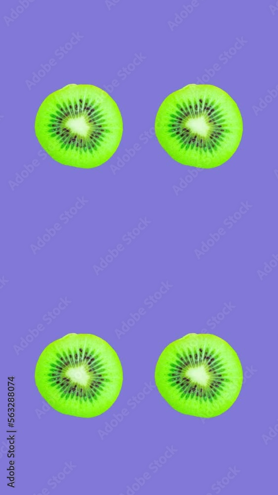 Poster kiwi slices rotating on purple background. healthy eating concept. vertical video with copy space fo