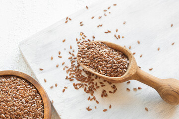 Heap of Flax seeds or linseeds in spoon on rustic background. Flaxseed concept, dietary fiber background