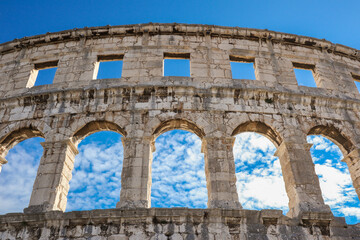 Obraz premium Below View of Pula Arena in Croatia. Beautiful Famous Monument Roman Amphitheatre in Istria with Blue Sky with Clouds during Summer Day.