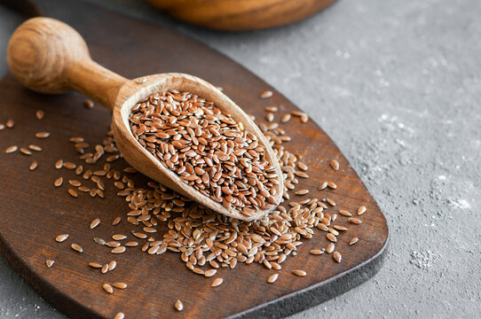 Heap of Flax seeds or linseeds in spoon on rustic background. Flaxseed concept, dietary fiber background