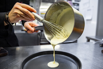 Chef in a restaurant or hotel kitchen cooking sauce