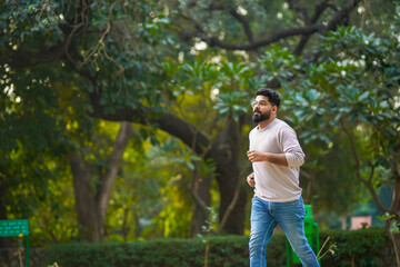 Young indian man running or jogging at park.
