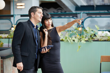 businesspeople or couple pointing to something in the office