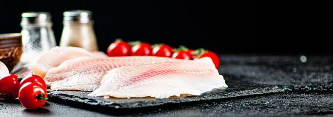Raw fish fillet with tomatoes and spices. 
