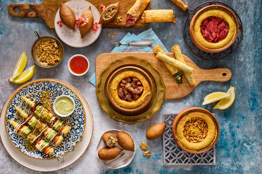 Assortment Of Hot Mezzah Plates On A Rustic Wooden Surface - Overhead View