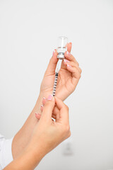 close-up of female caucasian hands holding a syringe and medicine