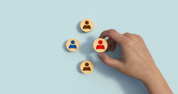 Human resource management and recruitment business concept. Hand holding wood cube with icon people on yellow background