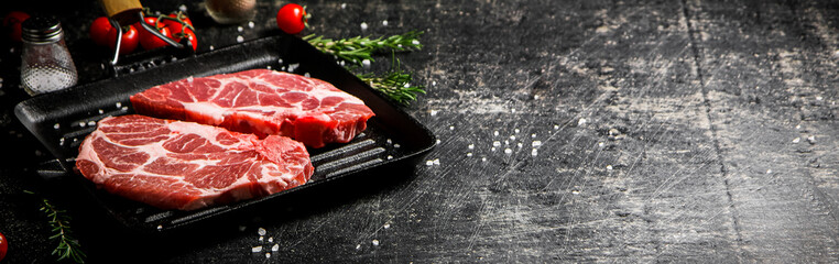 Raw pork steak in a frying pan. 