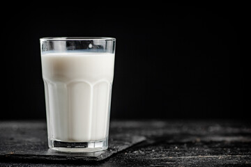 A glass of fresh milk on a stone board. 