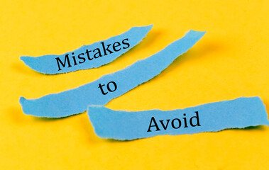 MISTAKES TO AVOID text on a blue pieces of paper on yellow background, business concept