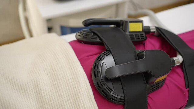 Woman getting ems treatment on her buttocks to burn fat and build muscles and remove cellulite