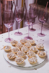 Table setting for a party - pink wine glasses and tartlets