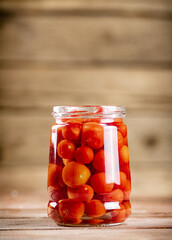 Pickled ripe tomatoes in a glass jar. 