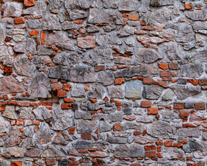 The old castle wall build from stones and bricks