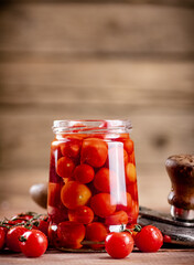 Pickled ripe tomatoes in a glass jar. 