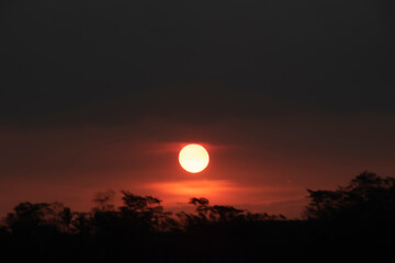 The sunset is blurry, the sky is red, refracted by the sun