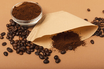 Coffee filter with ground coffee powder on a brown background. fragrant coffee beans for an energizing and invigorating drink. Hand Drip Coffee, Flat Lay of Manual Brew Coffee Tools