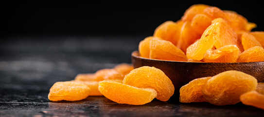 Full wooden plate with dried apricots. 