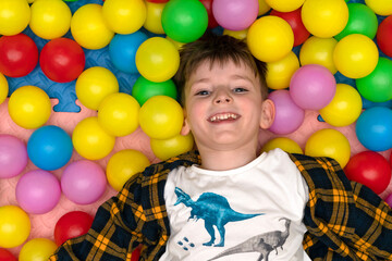 joyful boy among colored balloons