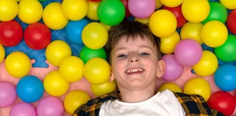 Fototapeta na wymiar joyful boy among colored balloons