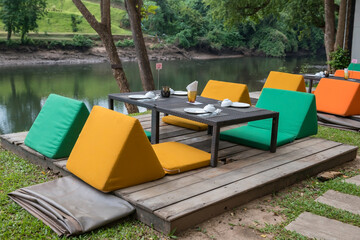 restaurant table and colorful sofa seats by kwai river, Kanchanaburi