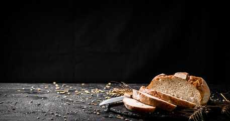 Sliced on a stone board wheat bread with grains. 