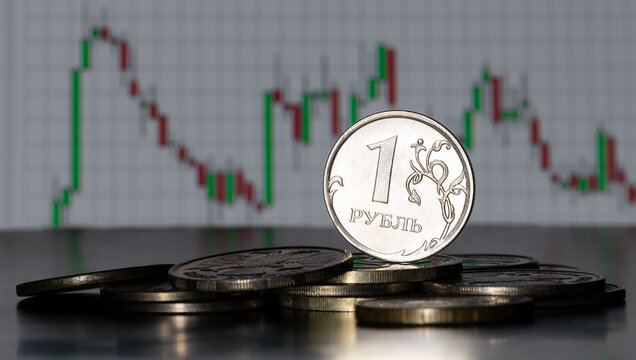 Coin of 1 Russian ruble denomination against the background of stock data chart