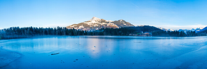 Fototapeta na wymiar Schwarzsee lake in Kitzbuhel partly covered with ice. Winter in Austria