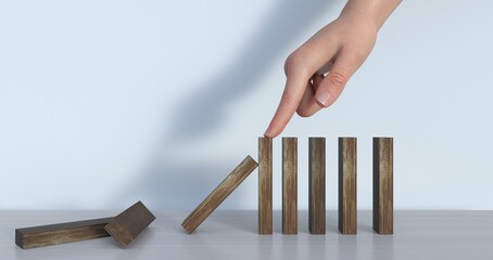 Hand stopping wooden domino business crisis effect or risk protection concept