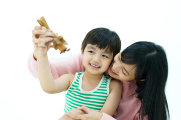 Happy Asian little young boy playing a wooden airplane toy with his mother, a boy dreams to future occupation or career.