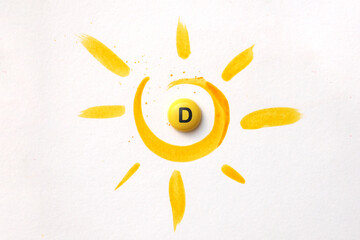 Fototapeta A tablet with the inscription Vitamin D in the center of the sun obraz