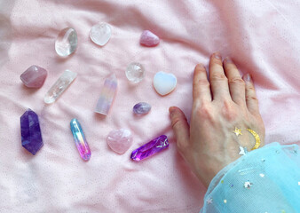 beautiful esoteric magical background. the magician's hand holds, selects the necessary crystals and minerals for a session of harmonization, crystal therapy, healing