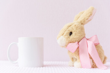 Easter mockup white blank mug with rabbit on pink cover background, copyspace.