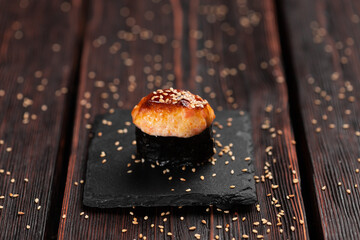Baked shrimp gunkan on wooden background. Simple gunkan sushi with shrimp tartare with mayonnaise in minimal style. Japanese food - nigiri sushi in nori. Nigiri sushi with fish